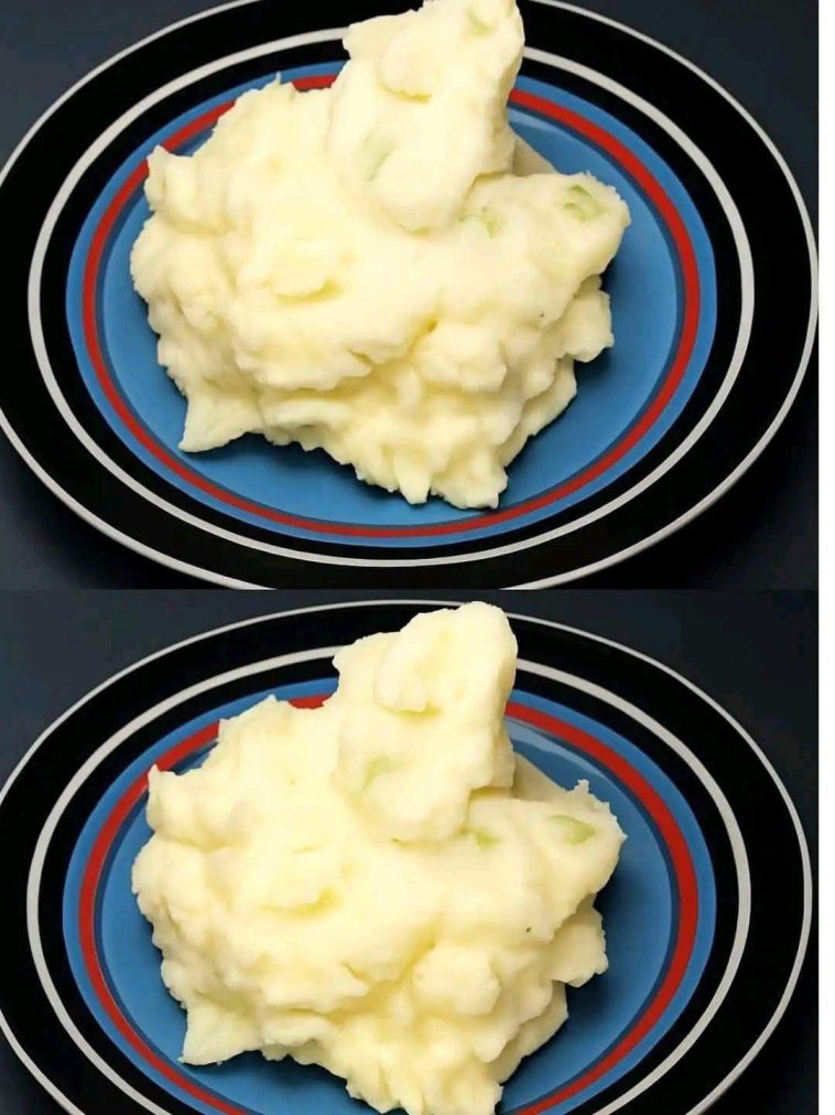 A bowl of creamy mashed potatoes, perfectly whipped to a smooth texture, topped with a pat of butter and garnished with freshly chopped parsley.