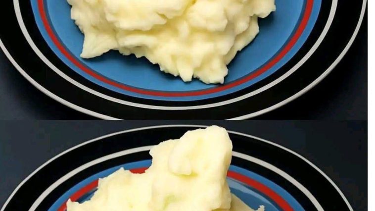 A bowl of creamy mashed potatoes, perfectly whipped to a smooth texture, topped with a pat of butter and garnished with freshly chopped parsley.